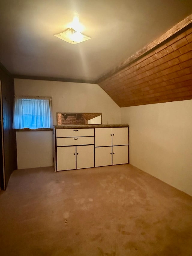 bonus room featuring light carpet and vaulted ceiling