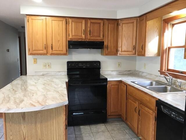 kitchen with black appliances, kitchen peninsula, sink, and light tile patterned floors