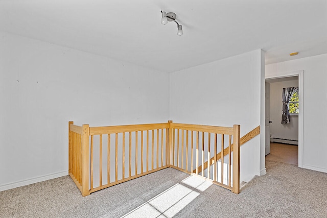 hall with light carpet and a baseboard heating unit