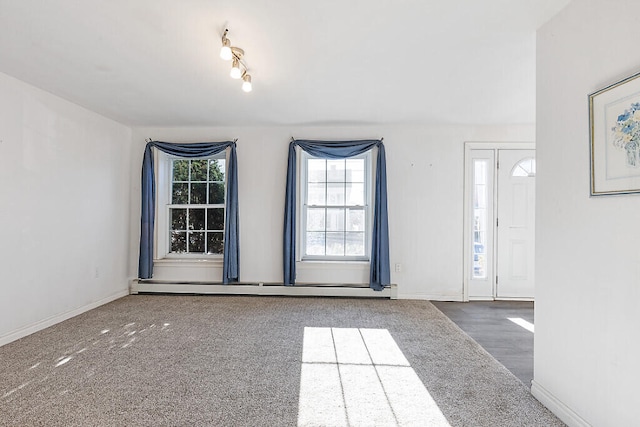 carpeted foyer entrance featuring a baseboard heating unit