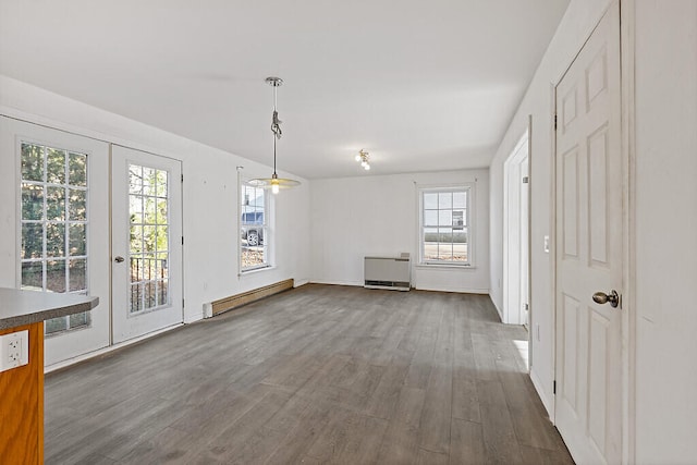 interior space with french doors, dark hardwood / wood-style flooring, plenty of natural light, and a baseboard heating unit