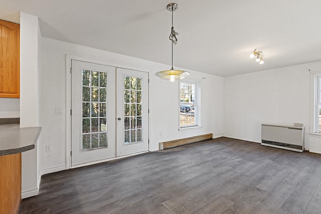 unfurnished dining area featuring french doors, radiator heating unit, baseboard heating, and dark wood-type flooring