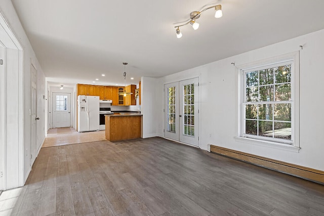 kitchen with french doors, light wood-type flooring, white appliances, decorative light fixtures, and a baseboard radiator