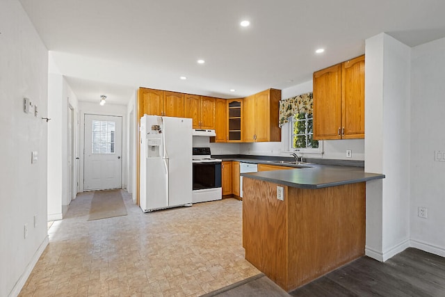 kitchen with sink, white appliances, and kitchen peninsula