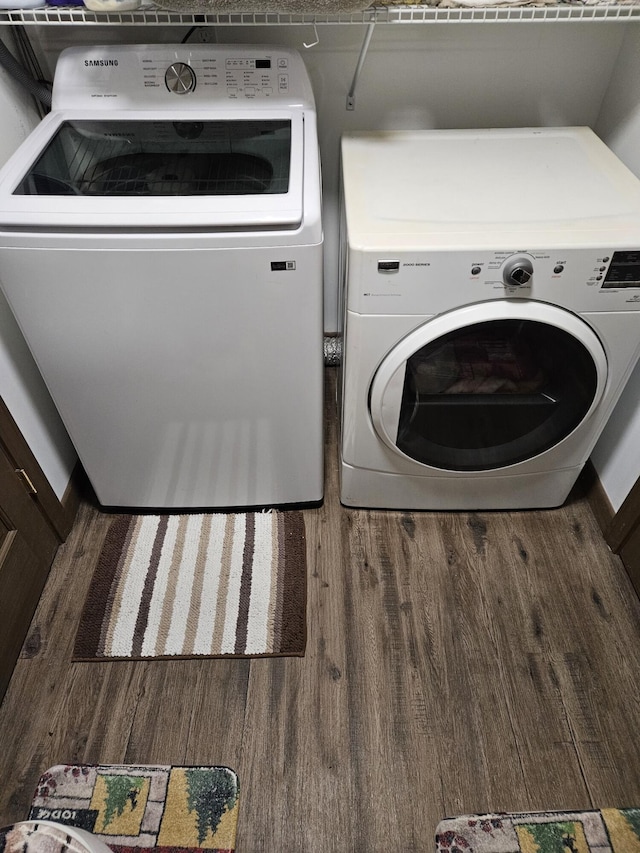 clothes washing area with dark wood-type flooring and washing machine and clothes dryer