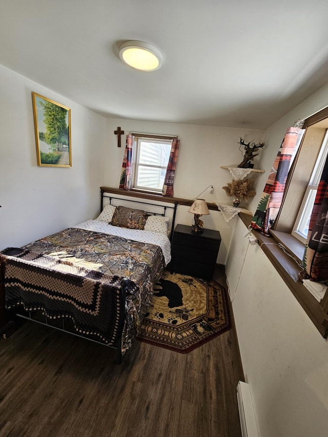 bedroom with wood-type flooring and baseboard heating