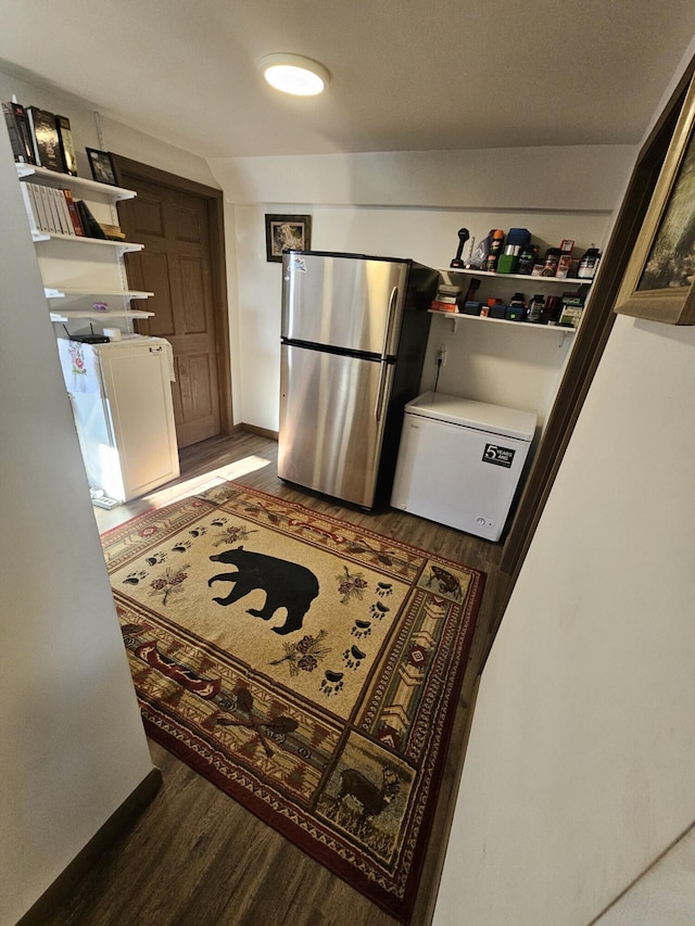 kitchen with refrigerator, dark hardwood / wood-style flooring, washer / clothes dryer, and stainless steel refrigerator