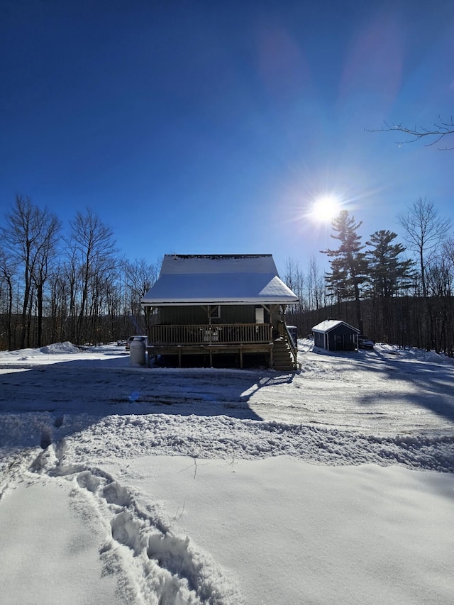 snow covered house with a wooden deck