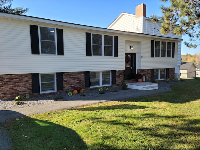 2 Old County Rd, Veazie, ME 04401 - bi-level home featuring a front lawn, brick siding, and a chimney