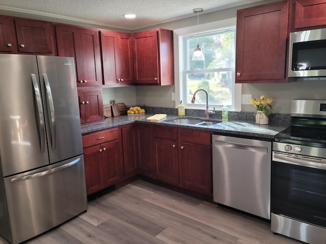 2 Old County Rd, Veazie, ME 04401 - kitchen with stainless steel appliances, a sink, reddish brown cabinets, a textured ceiling, and light wood-type flooring
