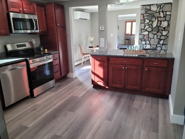 2 Old County Rd, Veazie, ME 04401 - kitchen with appliances with stainless steel finishes, dark brown cabinets, a wall mounted AC, a baseboard radiator, and light wood-style floors