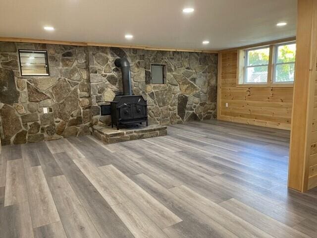 2 Old County Rd, Veazie, ME 04401 - unfurnished living room featuring wood finished floors, a wood stove, recessed lighting, and wooden walls