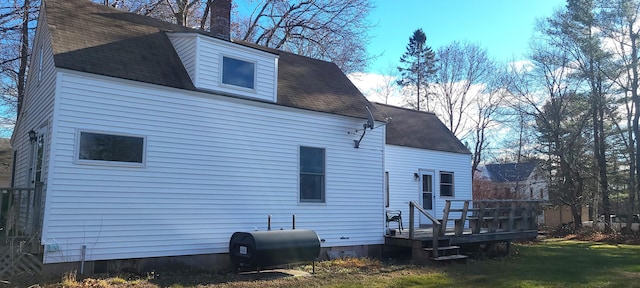 rear view of house with a lawn and a wooden deck