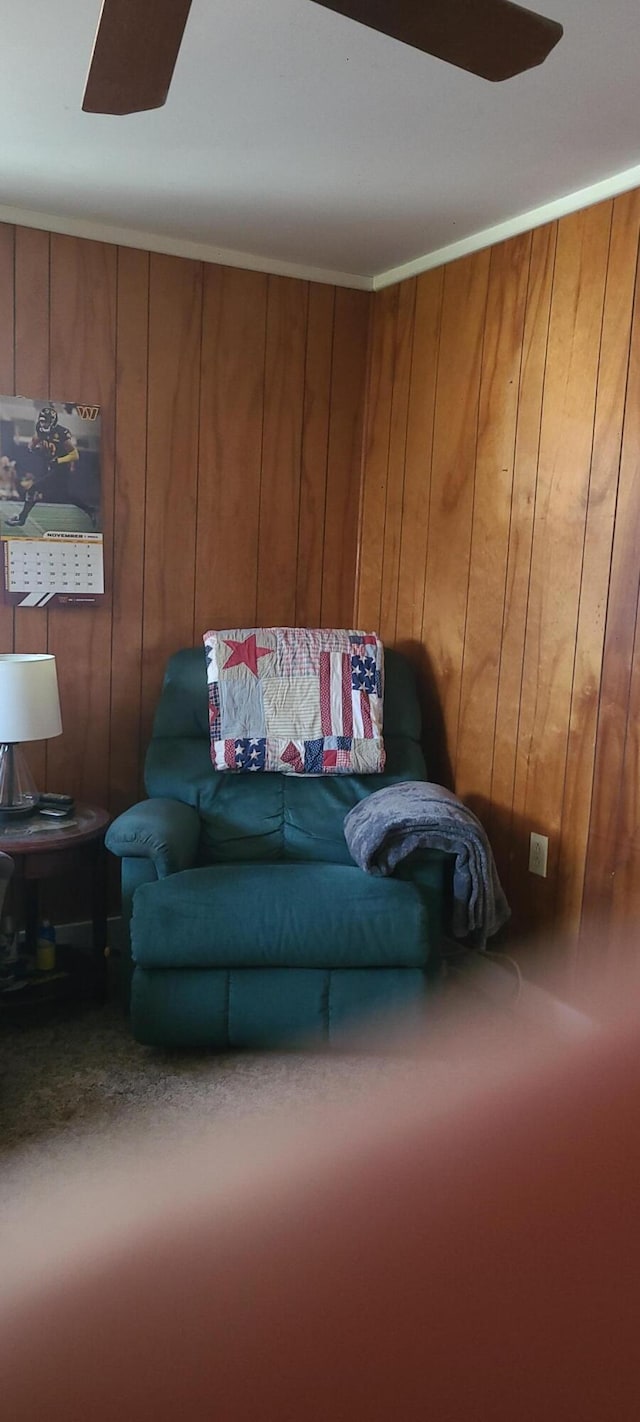 carpeted living room featuring wooden walls