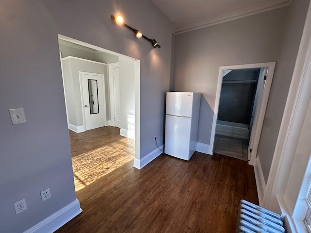 kitchen featuring radiator, dark hardwood / wood-style flooring, ornamental molding, and white refrigerator