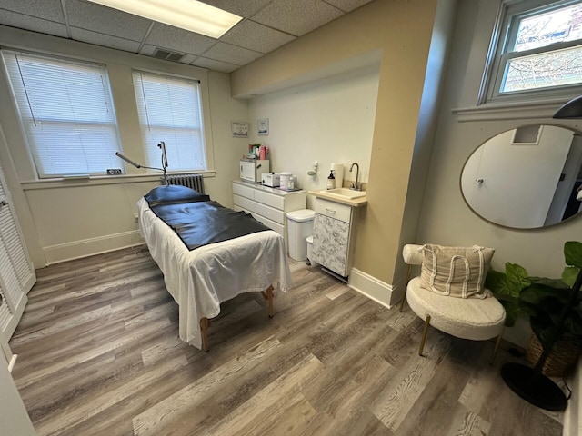 bedroom featuring a drop ceiling, dark hardwood / wood-style flooring, and sink