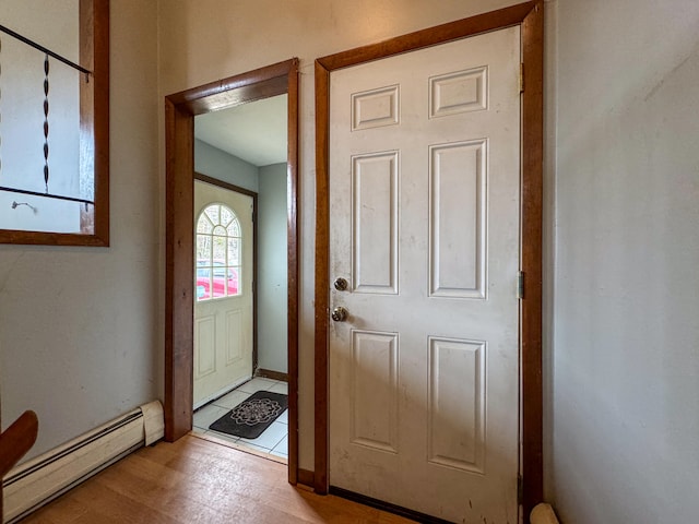 doorway to outside with light hardwood / wood-style flooring and a baseboard heating unit