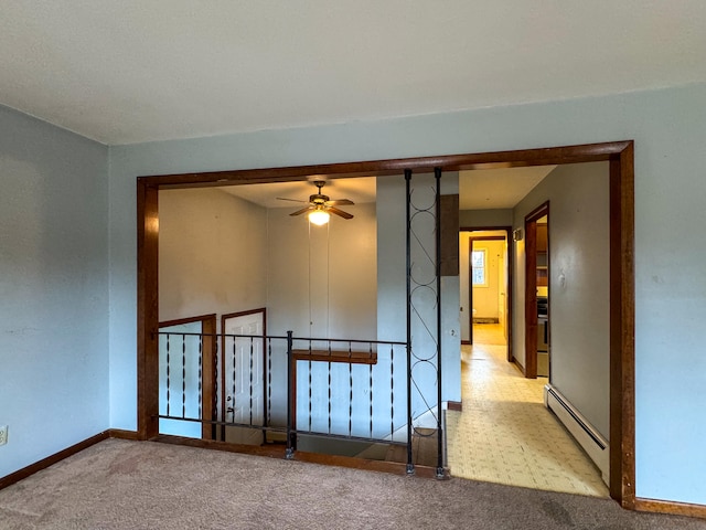 spare room featuring baseboard heating, light carpet, and ceiling fan