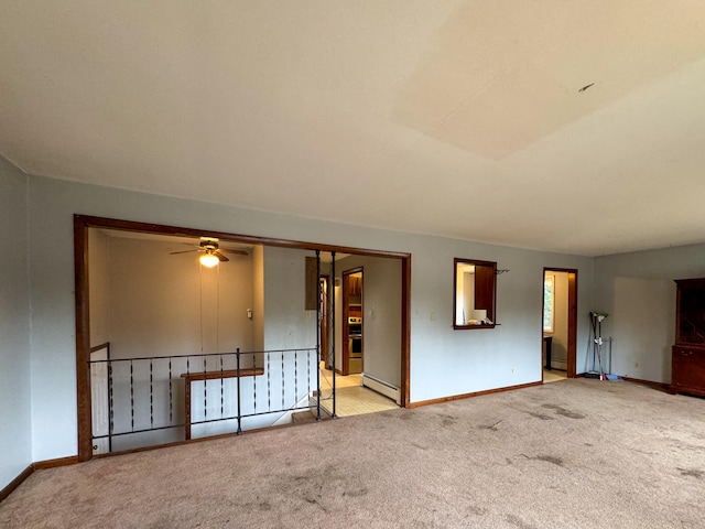 carpeted spare room with ceiling fan and a baseboard radiator