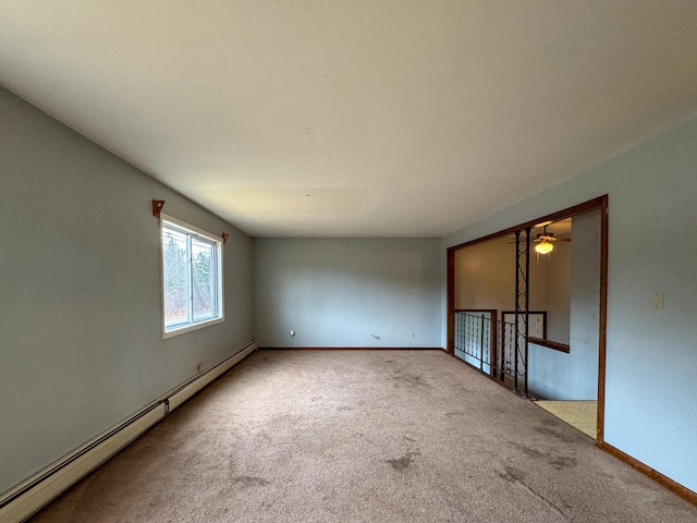 carpeted empty room with a baseboard heating unit