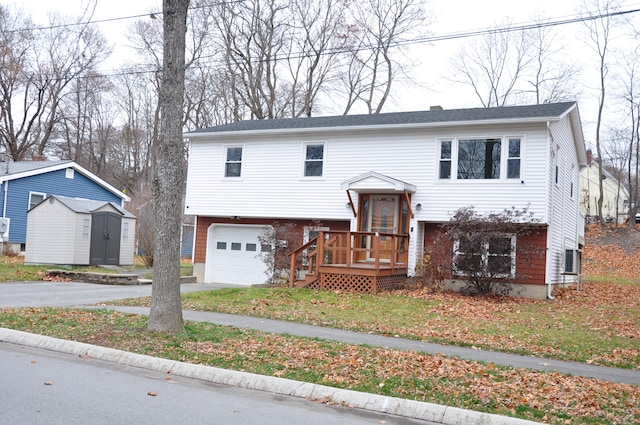 bi-level home with a garage, a shed, and a front lawn