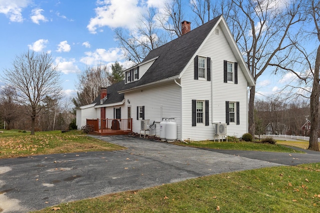 544 Main Rd N, Hampden, ME 04444 - view of side of property featuring a shingled roof, a wooden deck, a chimney, asphalt driveway, and a yard