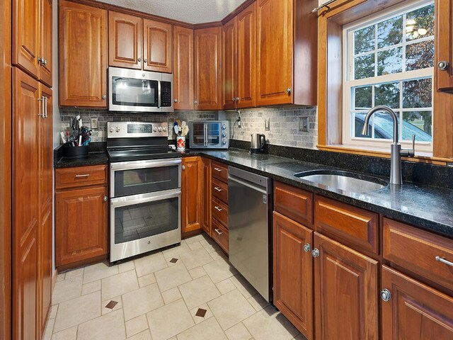 544 Main Rd N, Hampden, ME 04444 - kitchen featuring stainless steel appliances, a sink, backsplash, and dark stone countertops