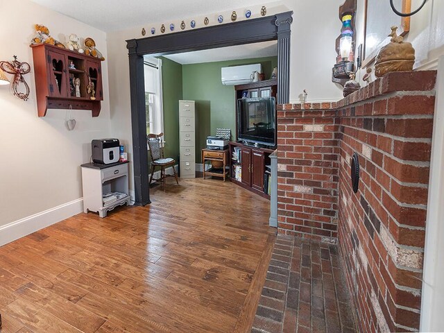 544 Main Rd N, Hampden, ME 04444 - living room featuring a wall mounted AC, wood finished floors, and baseboards