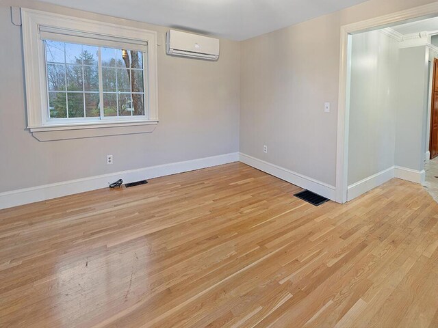 544 Main Rd N, Hampden, ME 04444 - unfurnished room featuring a wall mounted AC, baseboards, and light wood-style floors