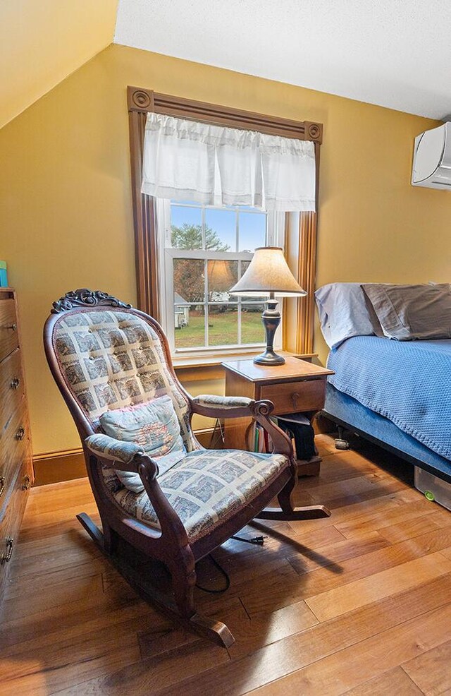 544 Main Rd N, Hampden, ME 04444 - bedroom with wood-type flooring, a wall mounted AC, and lofted ceiling