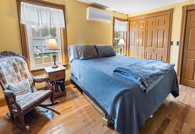 544 Main Rd N, Hampden, ME 04444 - bedroom with a wall unit AC, hardwood / wood-style flooring, and a closet