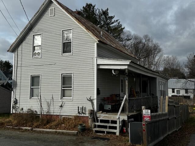 rear view of property featuring a porch