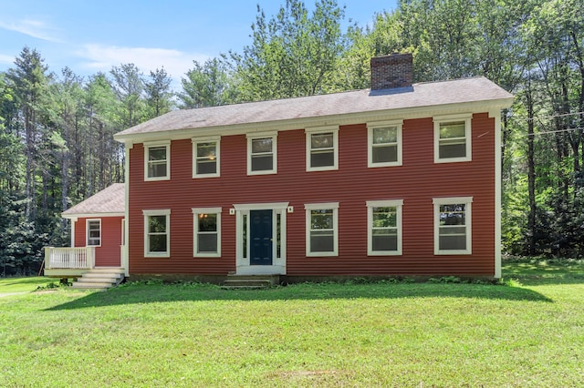 colonial inspired home featuring a front lawn