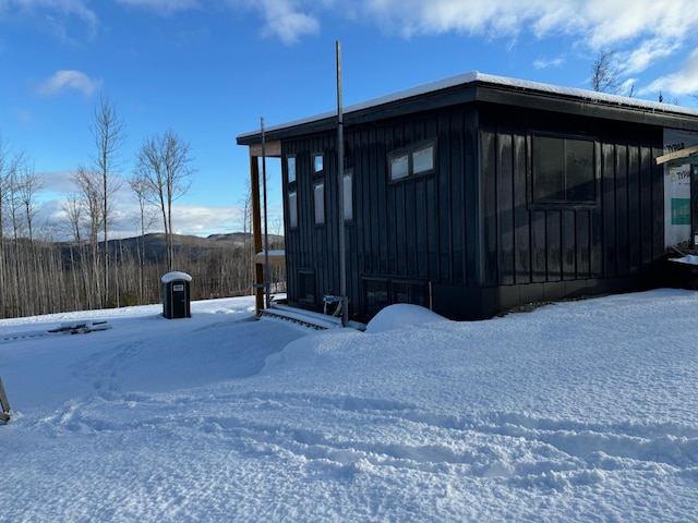 view of snow covered exterior featuring board and batten siding