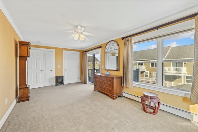 misc room with light carpet, ceiling fan, crown molding, a baseboard radiator, and a wood stove