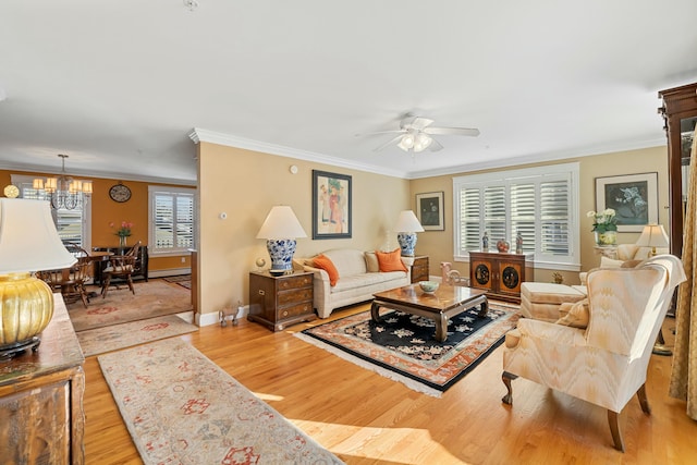 living room with light hardwood / wood-style flooring, a wealth of natural light, and crown molding