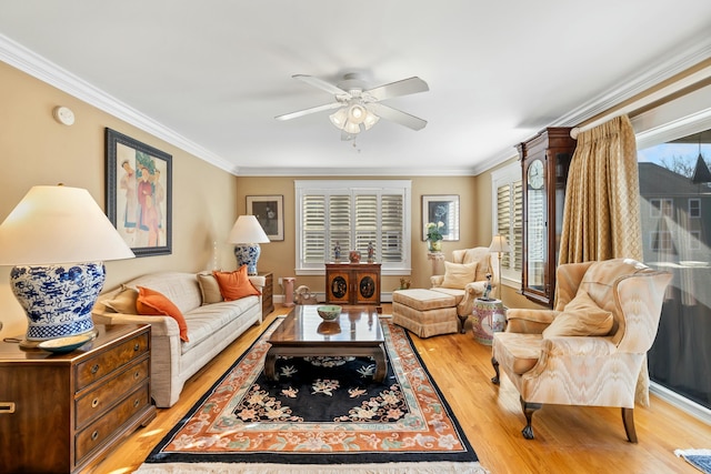 living room featuring ceiling fan, light hardwood / wood-style floors, crown molding, and a baseboard heating unit