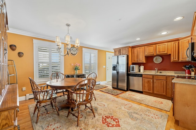 kitchen with ornamental molding, stainless steel appliances, pendant lighting, a chandelier, and light hardwood / wood-style floors