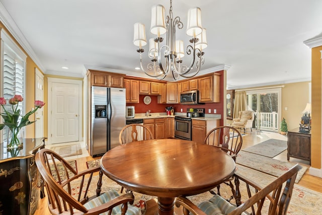 dining room with crown molding, light wood-type flooring, and an inviting chandelier