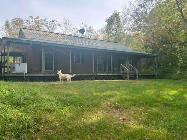 rear view of property featuring a lawn