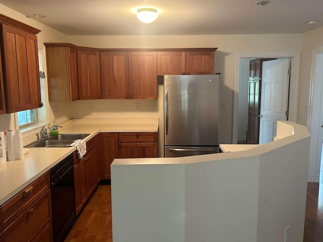 kitchen featuring stainless steel refrigerator, sink, dark hardwood / wood-style flooring, and black dishwasher