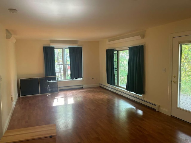 empty room with baseboard heating and dark wood-type flooring