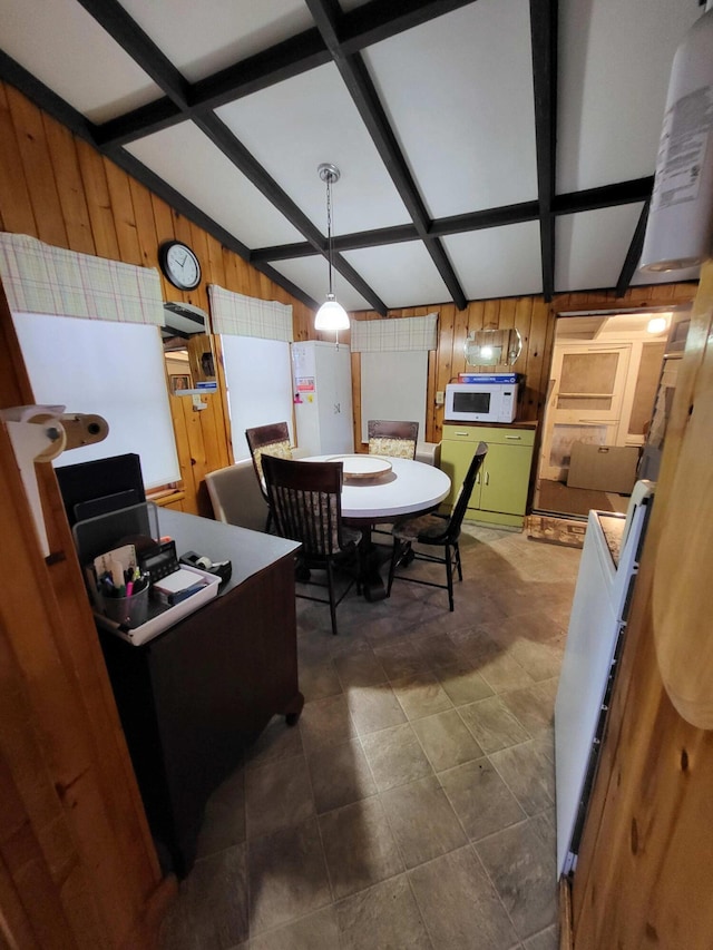 dining room featuring lofted ceiling with beams, wooden walls, and coffered ceiling