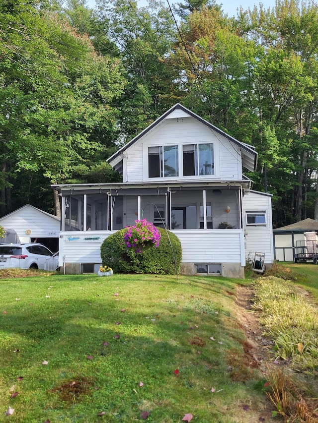 view of front of home with a front yard and a sunroom