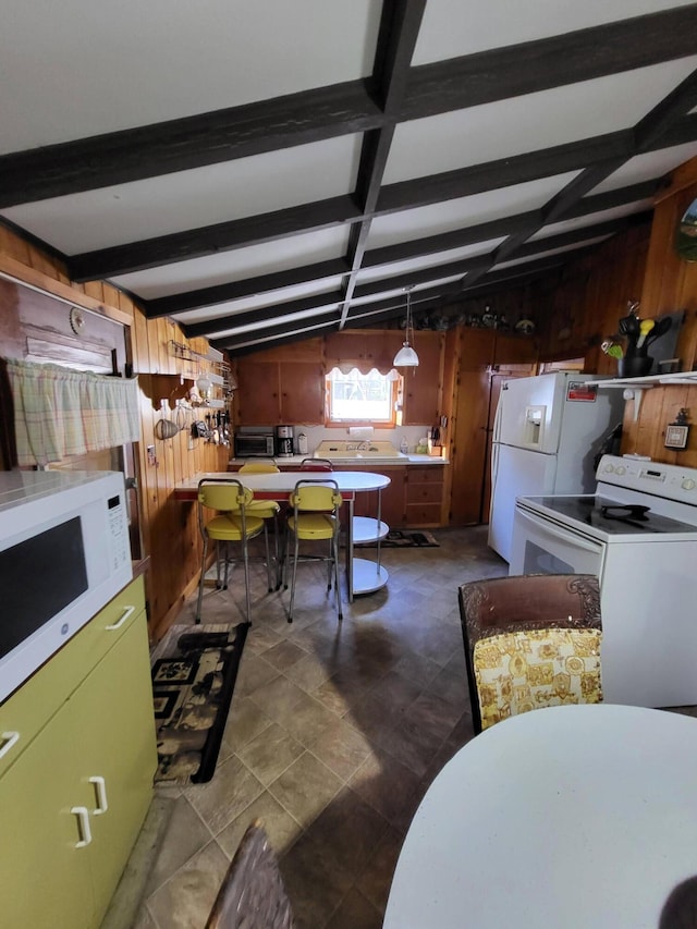 kitchen with wood walls, beamed ceiling, pendant lighting, and white appliances