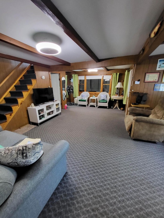 living room featuring beam ceiling, wood walls, and carpet