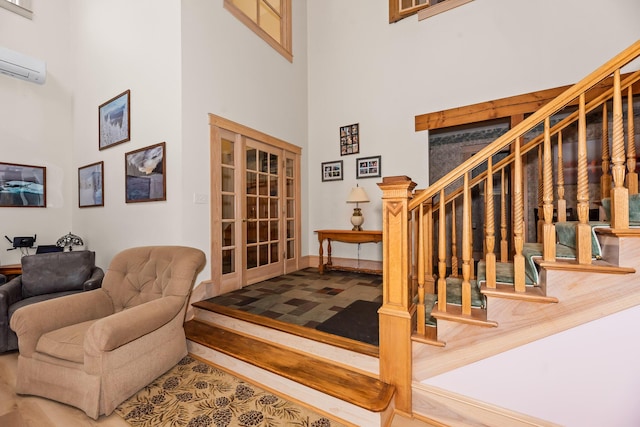 interior space featuring an AC wall unit, hardwood / wood-style floors, and a high ceiling