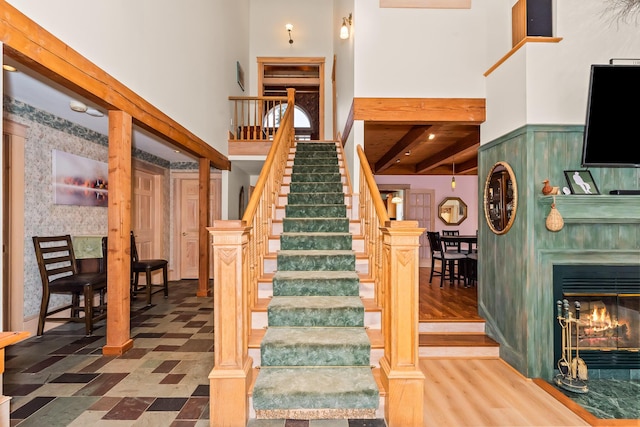 stairs with beamed ceiling and hardwood / wood-style flooring