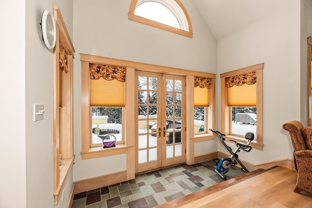 doorway with wood-type flooring, lofted ceiling, a wealth of natural light, and french doors