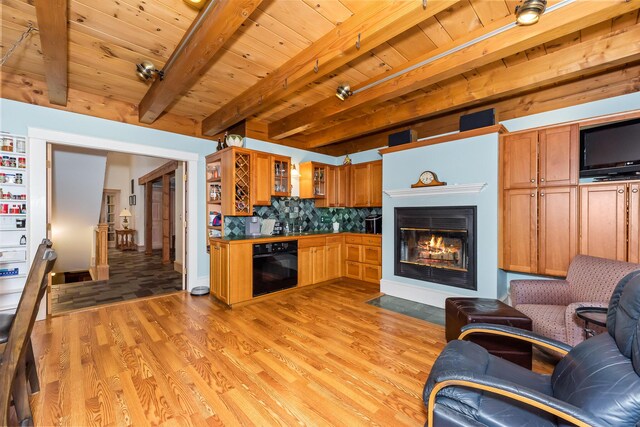 kitchen featuring beam ceiling, oven, light hardwood / wood-style flooring, and tasteful backsplash